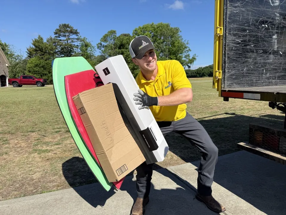 A Junk Doctors crew member carrying items to the truck